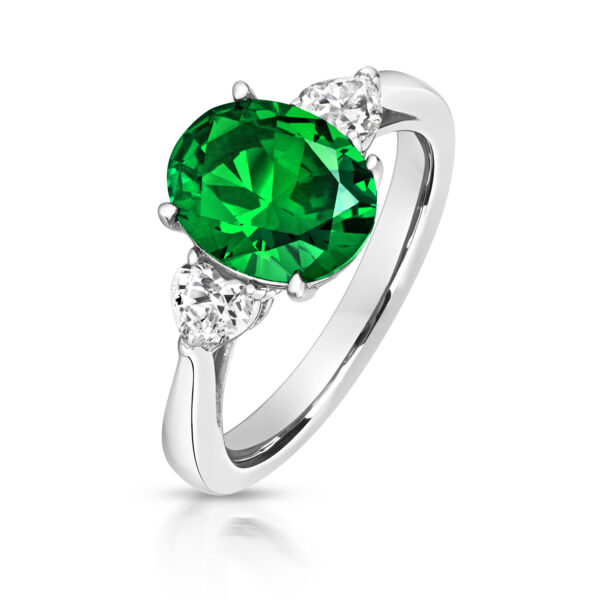 GREEN OVAL CENTRE STONE CLAW SET WITH HEART SHAPE SIDES TRILOGY RING
