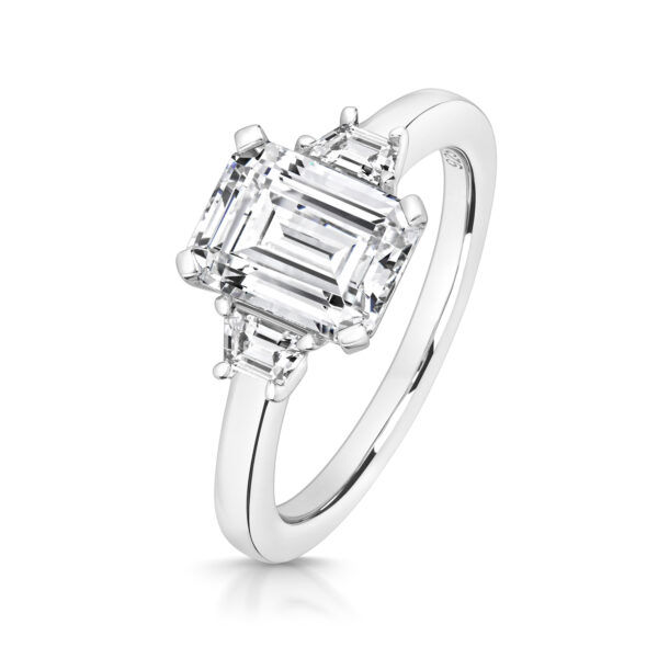 Sterling Silver Emerald Cut Centre Stone Claw Set With Trapezium Sides Trilogy Ring